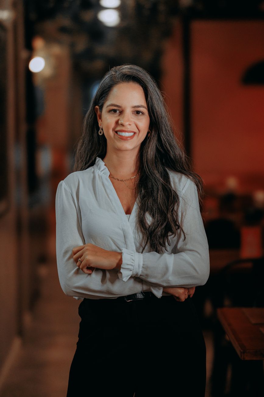 Portrait of a confident young woman smiling in an indoor setting. Bright and welcoming.