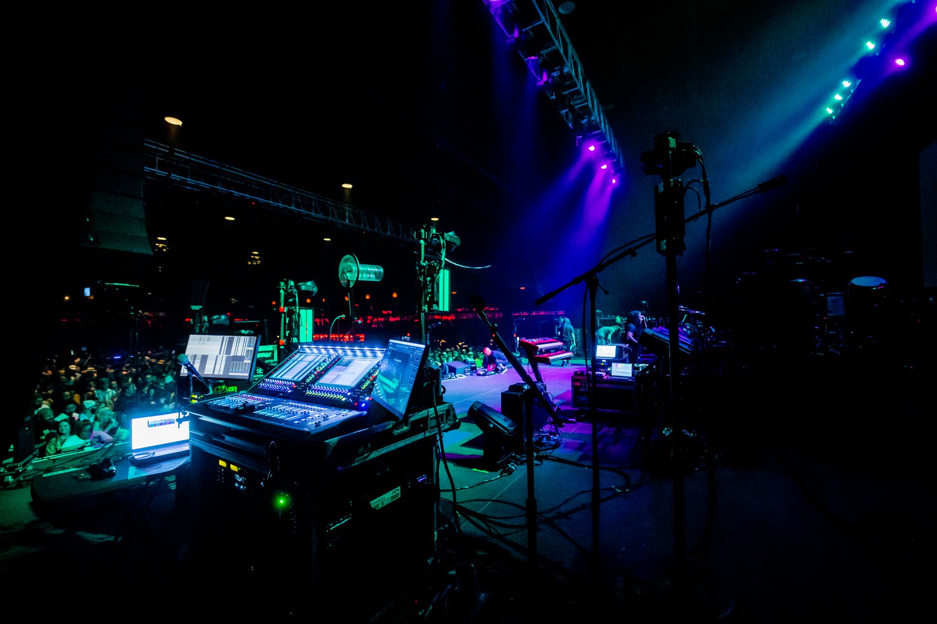 Energetic concert scene with illuminated stage and sound equipment.
